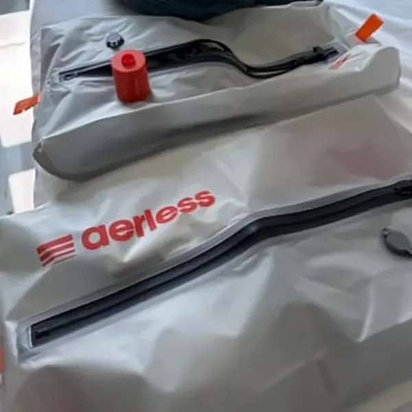 Close-up of the orange Aerless pump attached to the valve of a silver compression bag